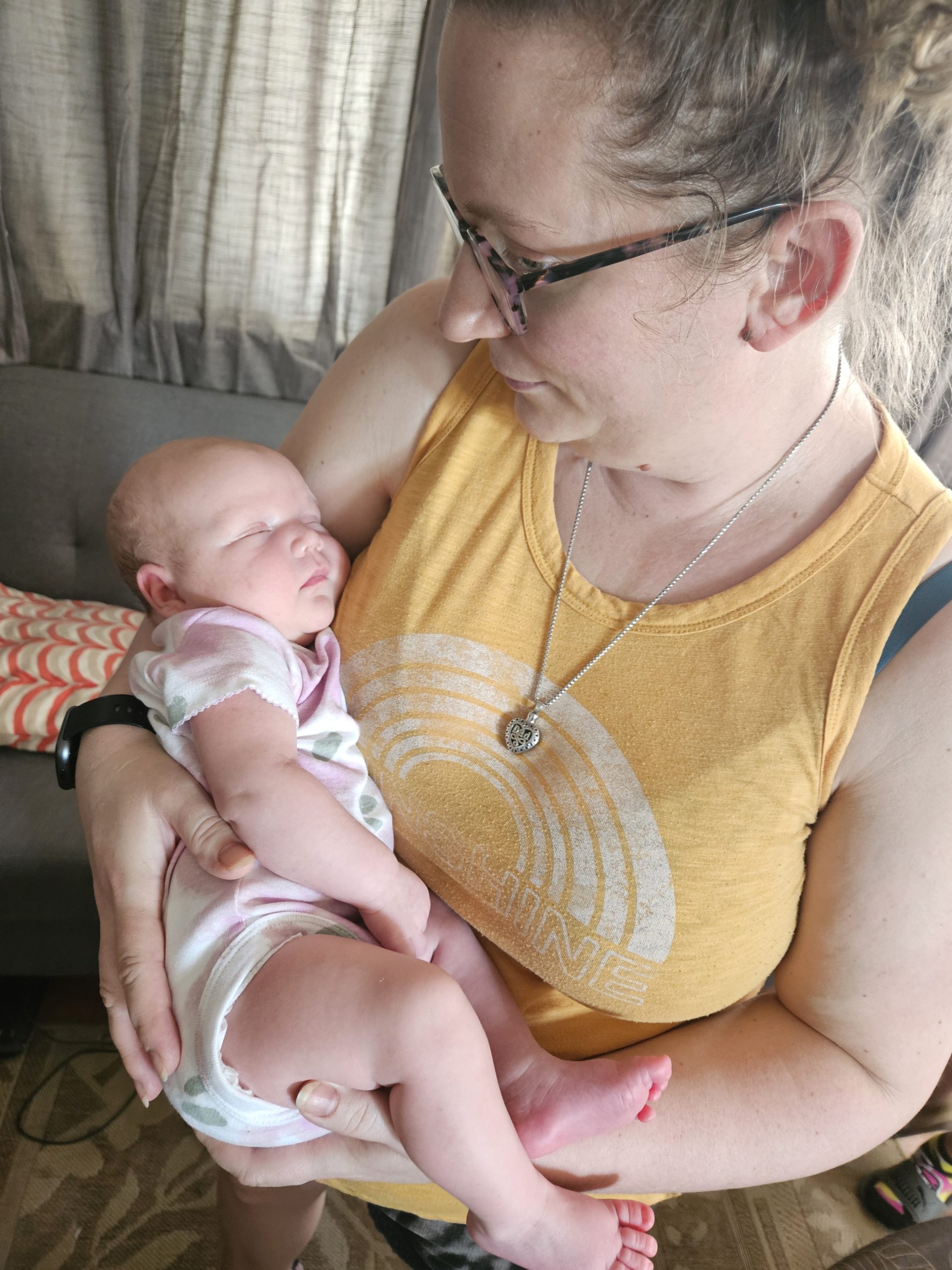 Surrogate holding newborn and looking down at baby